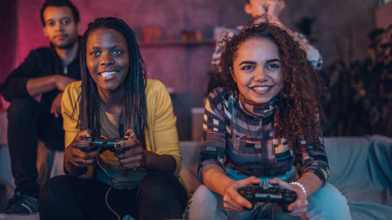 Imagem mostra três gamers negros. Um menino e duas meninas.