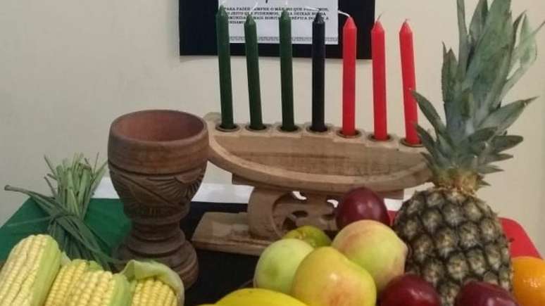 Mesa de celebração do Kwanzaa com velas e frutas