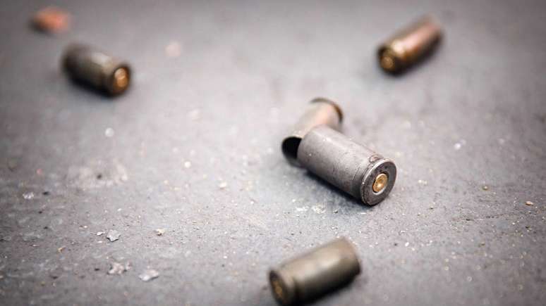 Imagem mostra balas de arma de fogo no asfalto.