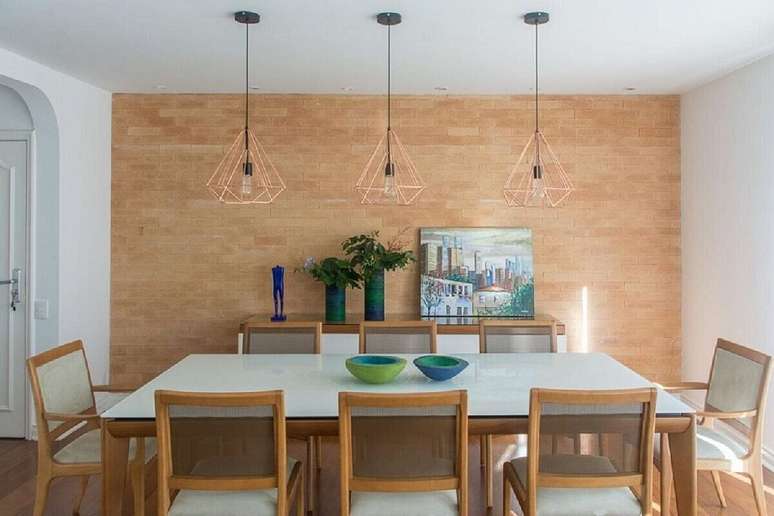 4. Lustre aramado rose gold para sala de jantar decorada com parede tijolinho e mesa branca &ndash; Foto: Viviane Gobbato