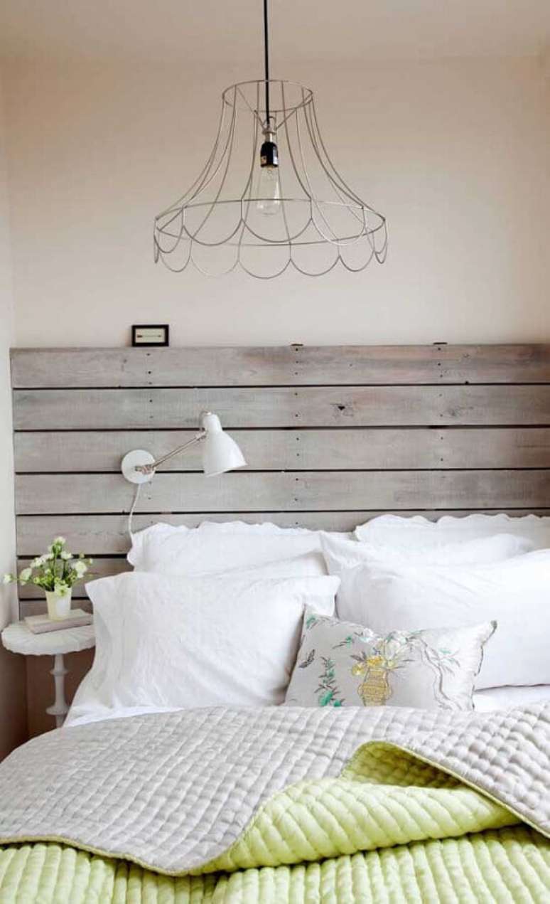 51. Quarto rustico decorado com cabeceira de madeira e lustre aramado &ndash; Foto: Houzz