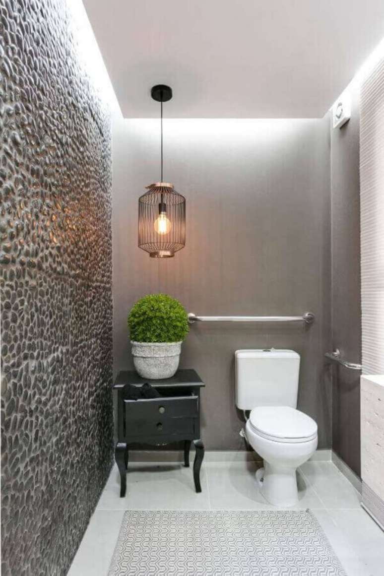 49. Parede de pedra para lavabo cinza decorado com lustre pendente aramado &ndash; Foto: Claudia Comparin