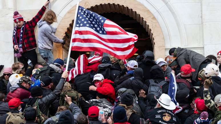 Apoiadores de Trump forçam passagem pela porta principal do Congresso dos EUA em 6 de janeiro de 2021