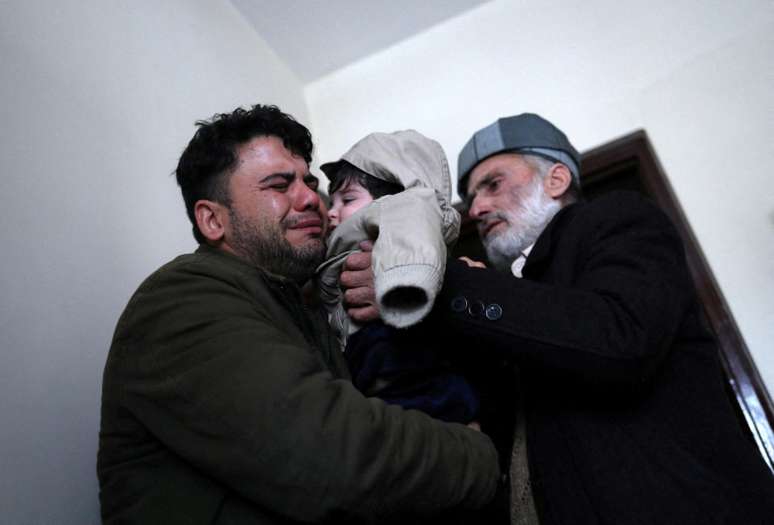 O taxista Hamid Safi, que encontrou o bebê, chora ao entregá-lo ao avô
