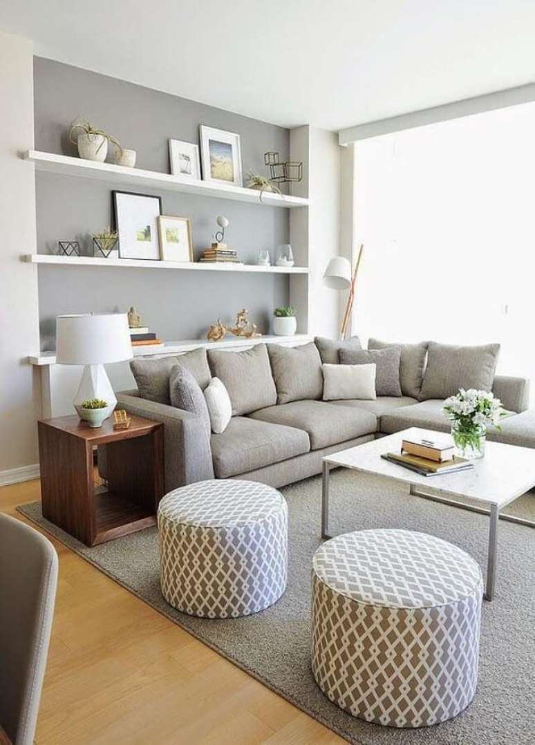32. Decora&ccedil;&atilde;o clean para sala cinza e branca com sof&aacute; de canto e puff redondo &ndash; Foto: Apartment Therapy