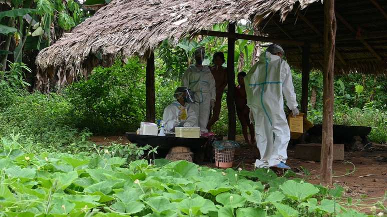 Equipe de saúde em aldeia para vacinar indígenas