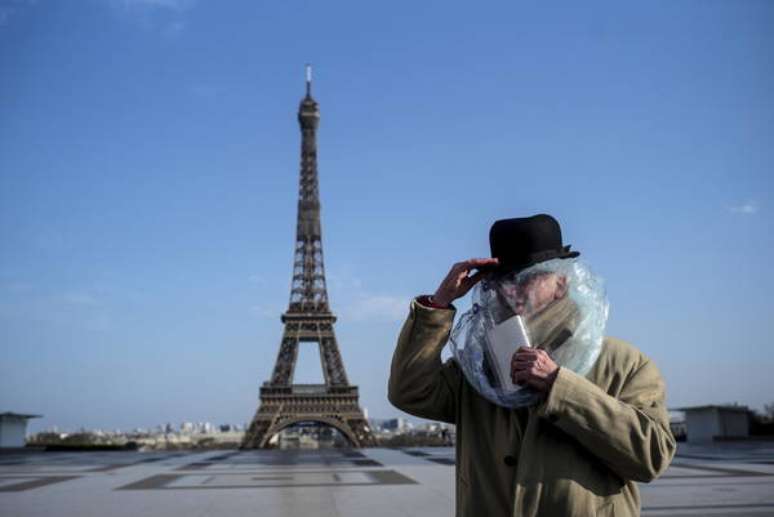 Homem vestido com saco plástico na cabeça para se proteger da Covid em Paris, capital da França