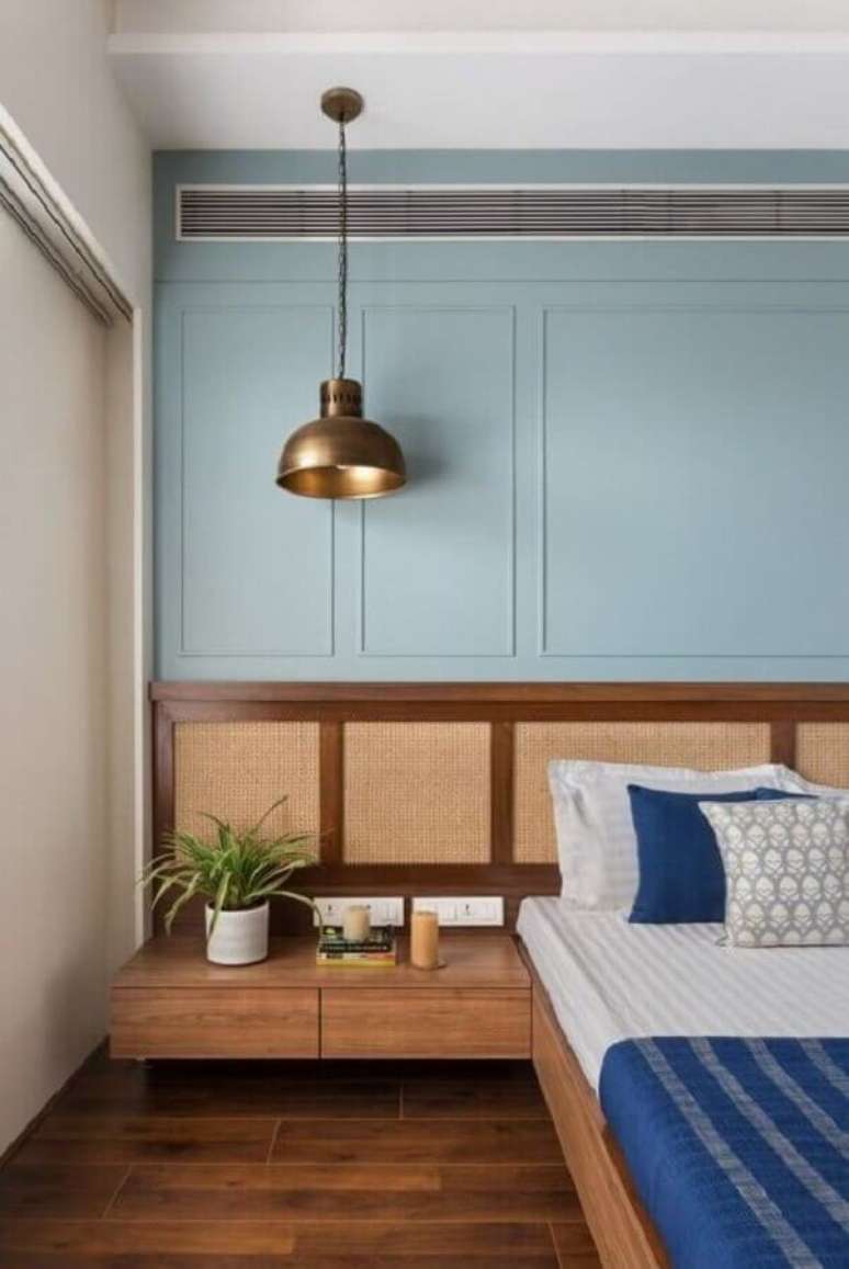11. Boiserie quarto com parede azul decorado com cabeceira planejada de madeira – Foto: The Architects Diary