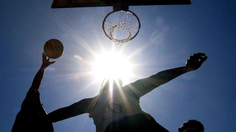 Imagens enquadra três homens jogando basquete