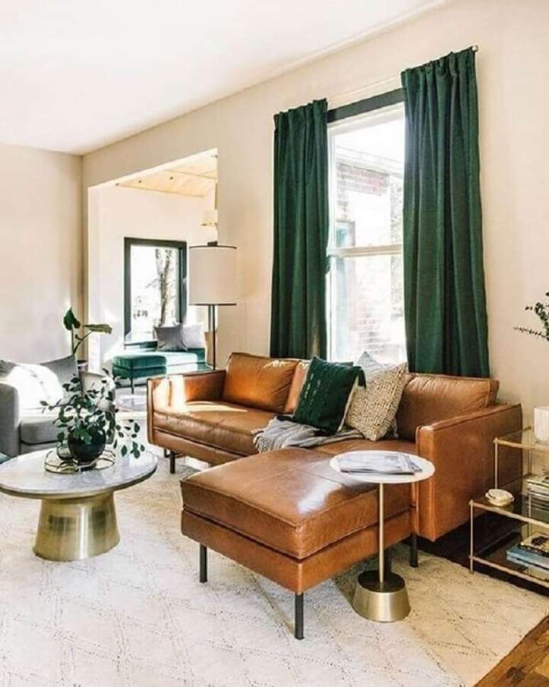 21. Sala de estar decorada com sof&aacute; de couro com chaise e cortina na cor verde escuro &ndash; Foto Estofos PT