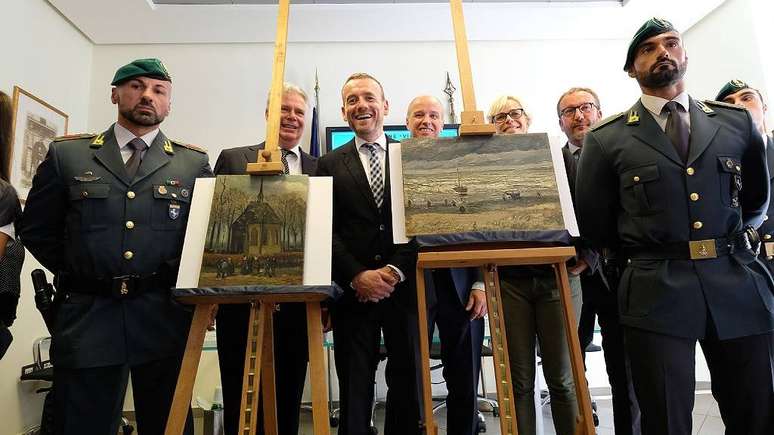 Axel Ruger (centro), diretor do museu Van Gogh, posa ao lado das duas pinturas recuperadas. Nápoles, em 30 de setembro de 2016
