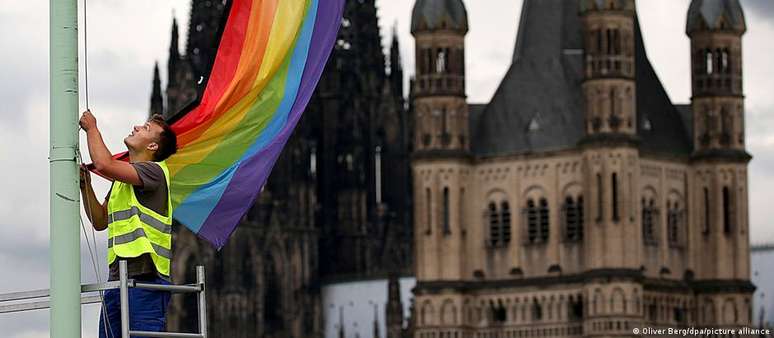 Uma bandeira do arco-íris é hasteada em frente à Catedral de Colônia e à Igreja de São Martinho (imagem de arquivo)