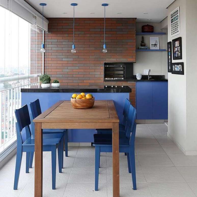 55. Parede de tijolinho para cantinho do churrasco pequeno decorado com bancada e cadeira azul – Foto: Decor Fácil