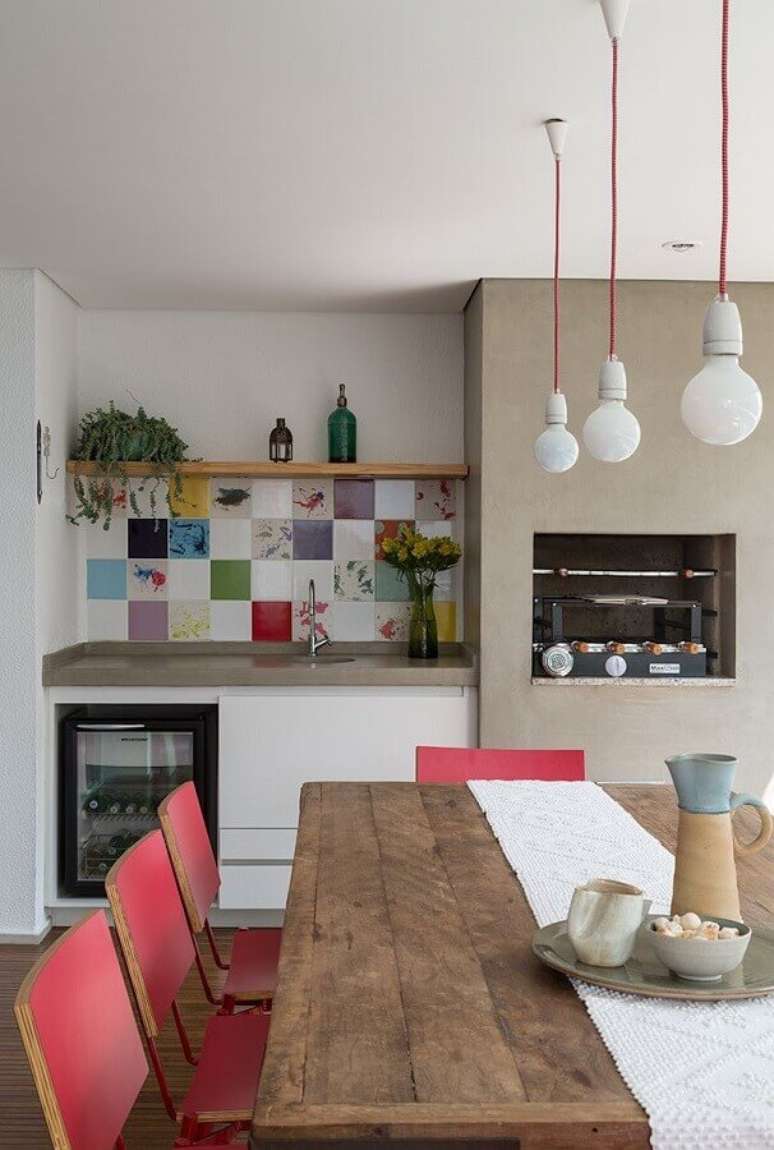 14. Cadeira vermelha para cantinho do churrasco pequeno decorado com mesa de madeira rústica – Foto: Lucia Manzano Arquitetura + Paisagismo