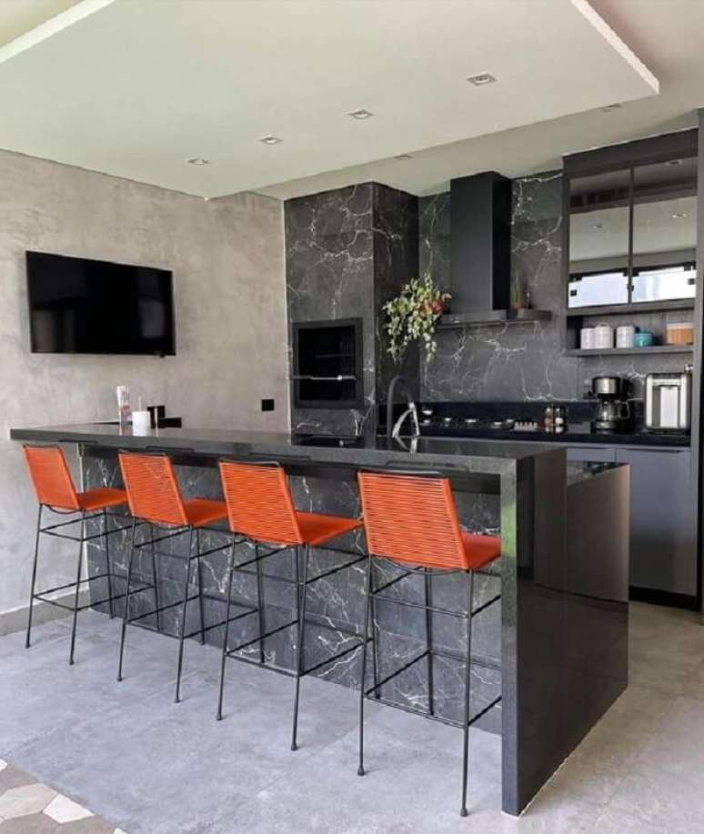 11. Banqueta alta para cantinho do churrasco preto moderno decorado com revestimento de m&aacute;rmore preto &ndash; Foto: Decor Salteado
