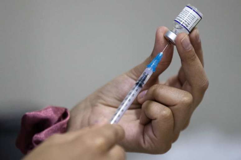 Uma enfermeira preparando a quarta dose da vacina anti-Covid