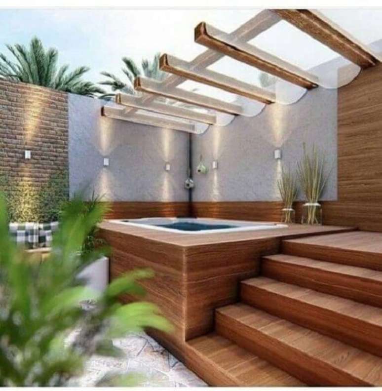 30. Piscina quadrada elevada com pergolado de vidro e deck – Foto Maison e Travaux