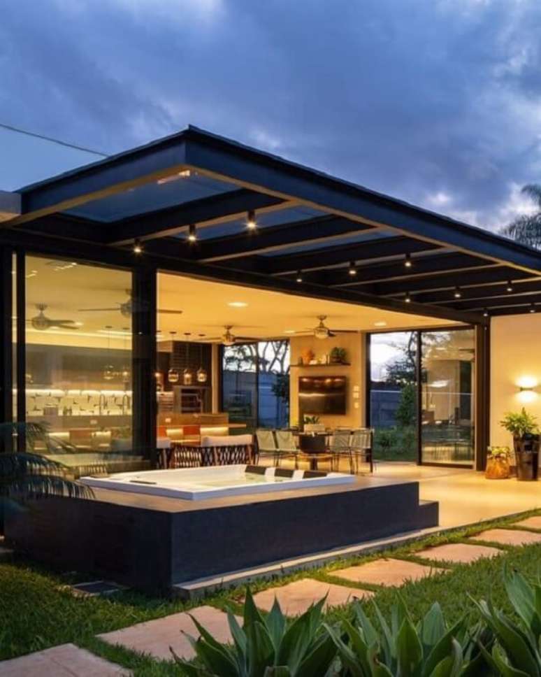 37. Pergolado de ferro suspenso e iluminado na &aacute;rea externa de casa &ndash; Foto Riolax Campinas