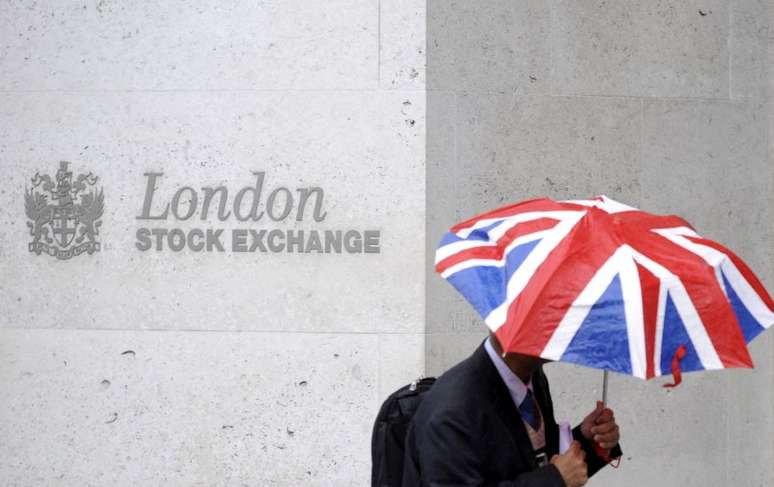 Pessoa se protege da chuva ao passar em frente ao prédio da Bolsa de Londres
01/10/2008
REUTERS/Toby Melville