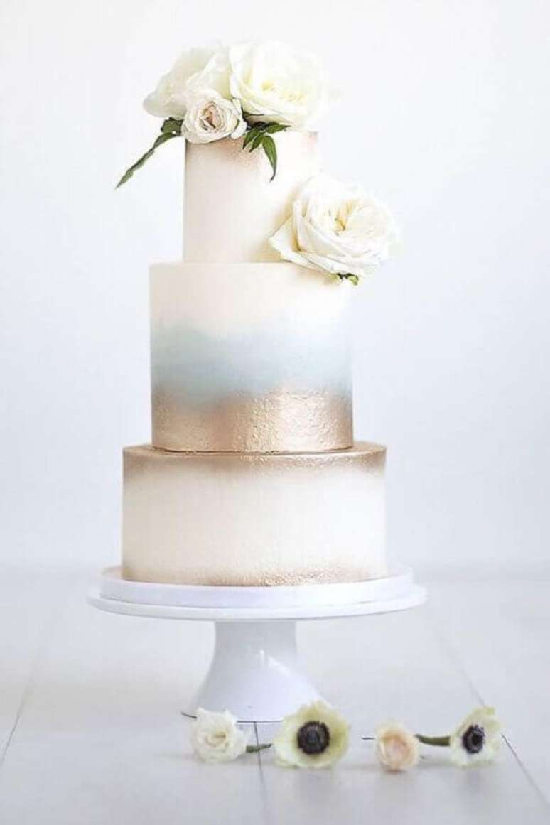 84. Lindo e moderno bolo de casamento com flores no topo e acabamento dourado &ndash; Foto: ELLE Decoration