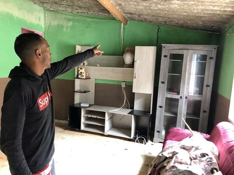 O comerciante Alexandre Greg&oacute;rio mostra rachadura na parede da casa de sua fam&iacute;lia