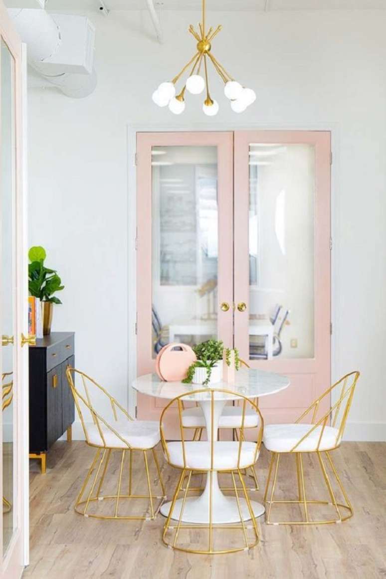 37. Sala de jantar com lumin&aacute;ria redonda e detalhes em dourado -Foto Fashionismo
