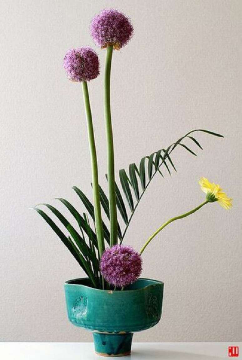 37. Ikebana delicada com vaso azul e flores em roxo e amarelo &ndash; Foto Venie Clayartist