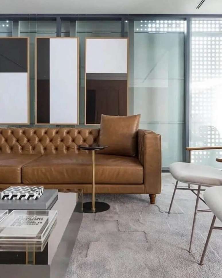 57. Sala moderna com sof&aacute; capiton&ecirc; marrom e mesa de centro espelhada. Fonte: Triplex Arquitetura