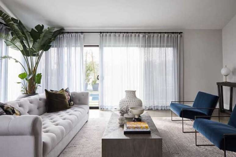 53. Sala de estar com poltronas azuis e sof&aacute; capiton&ecirc; branco. Fonte: Decor F&aacute;cil