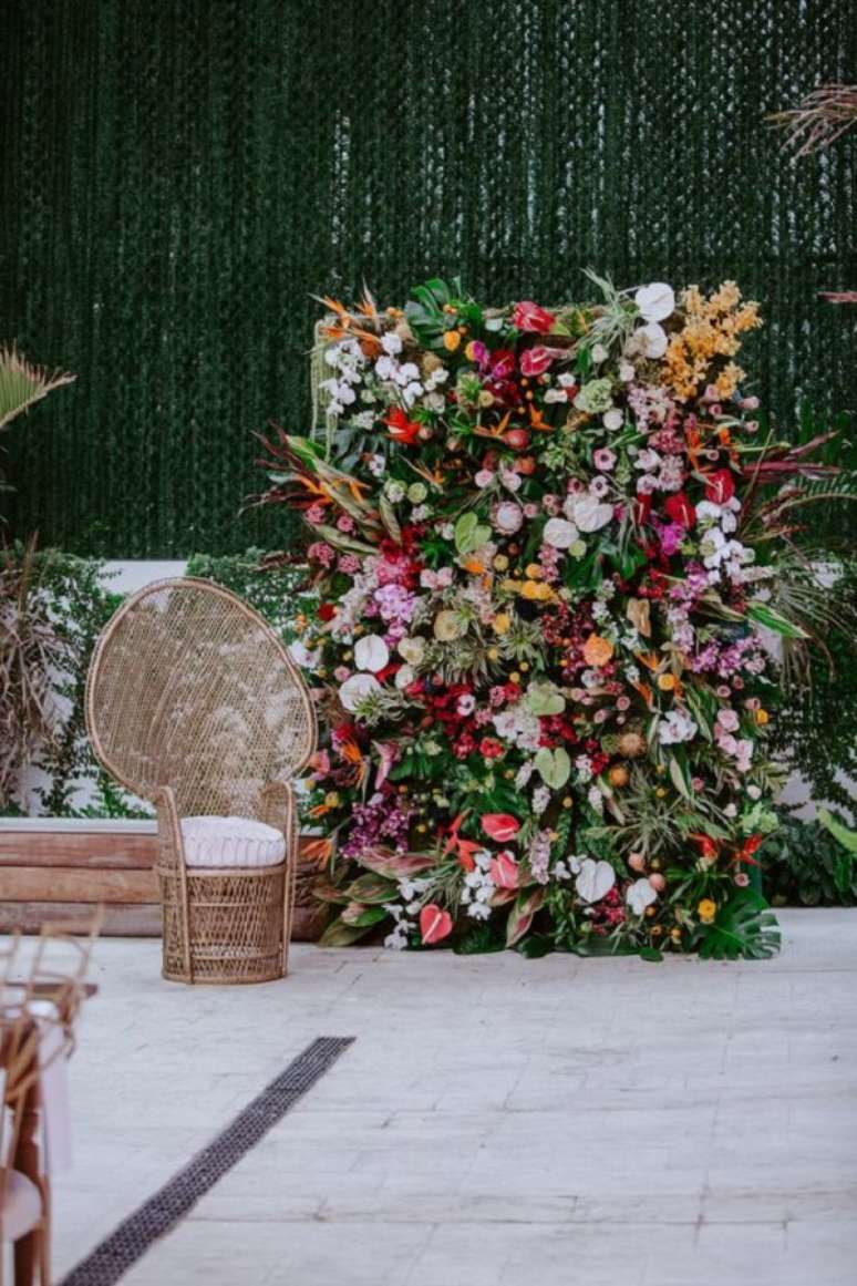 46. Painel de flores coloridas e poltrona de vime &ndash; Foto Here comes the Guide