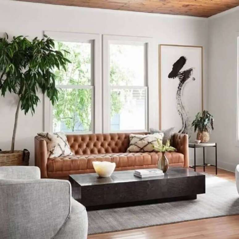 11. A mesa de centro moderna se harmoniza com o sof&aacute; capiton&ecirc; marrom. Fonte: Zin Home