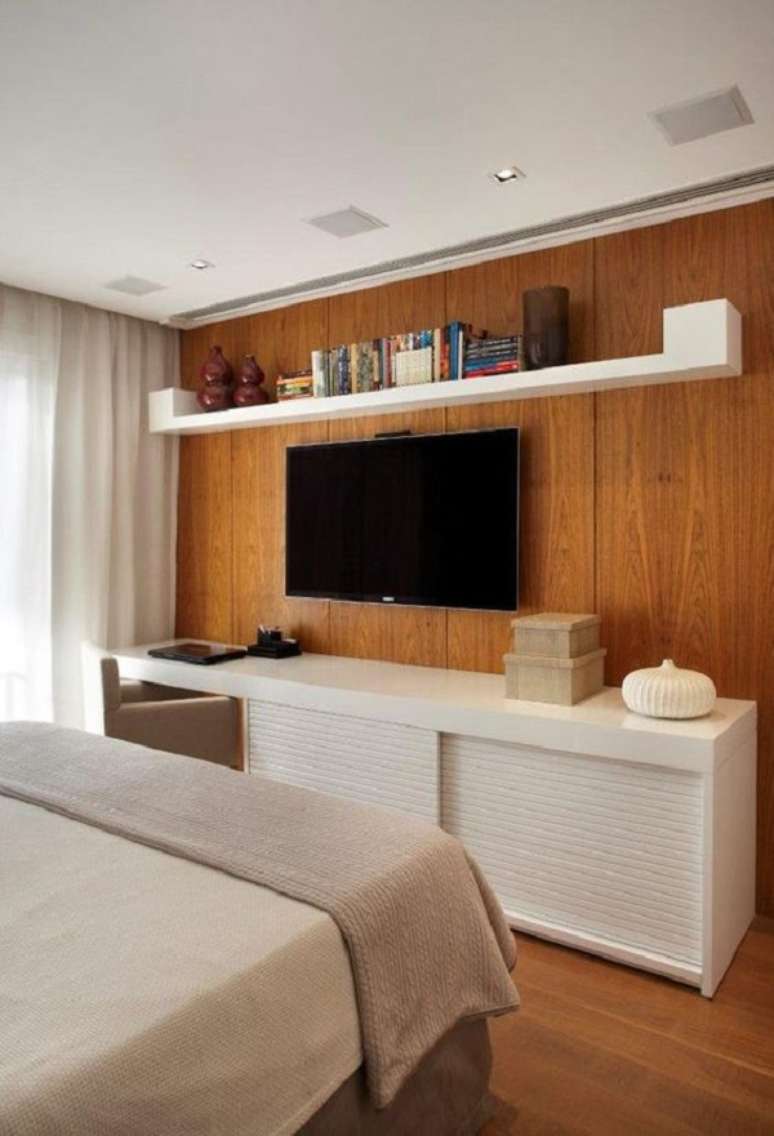 43. Rack minimalista para quarto com cama de casal moderna e paine de tv de madeira &ndash; Foto Casa Vogue