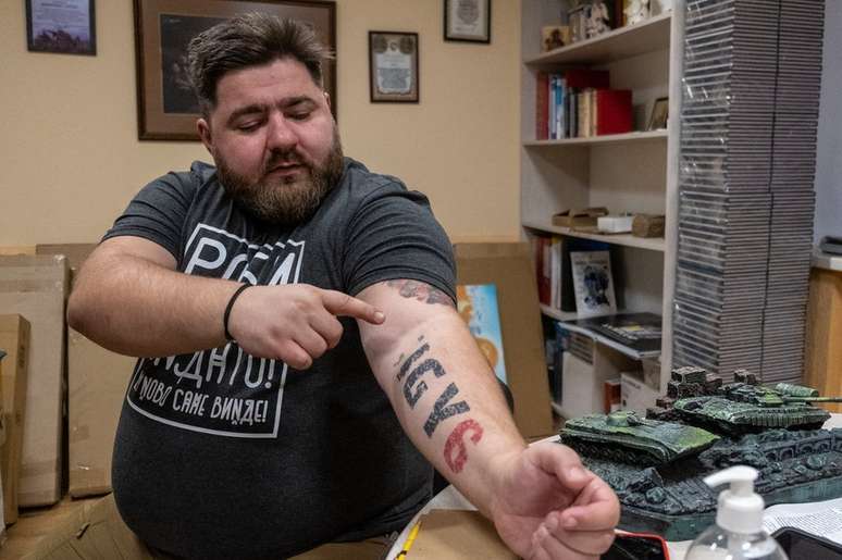 O psicólogo militar Andrii Kozinchuk mostra tatuagem que diz: 'Estou aqui te apoiando'