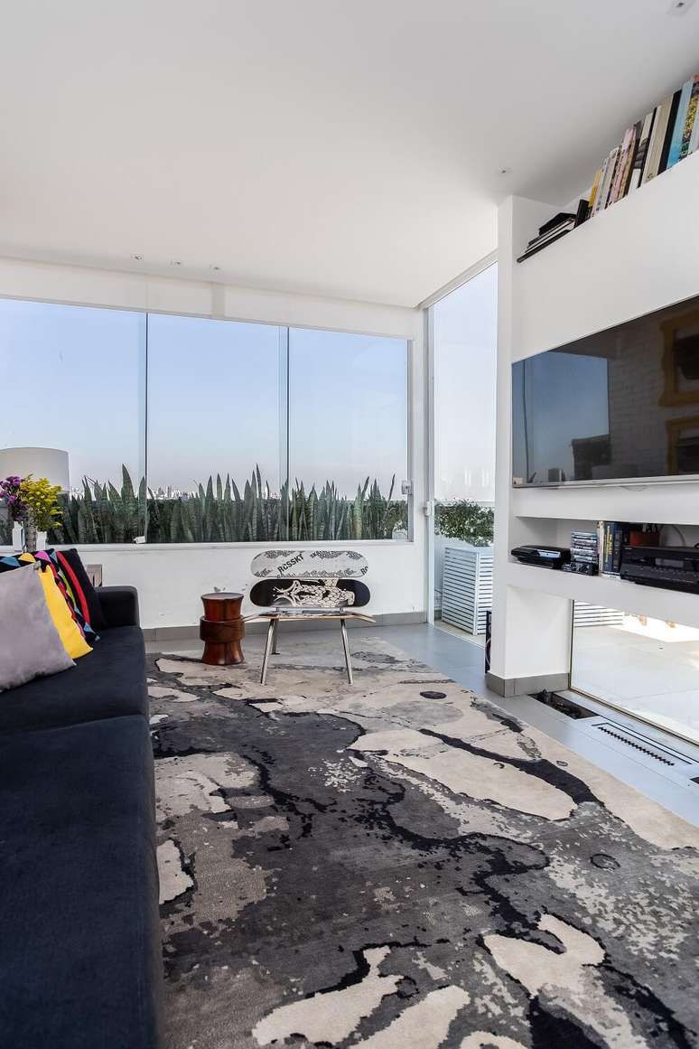 13. A arquiteta projetou uma aconchegante sala de estar com lareira e TV. Foto: JP Image