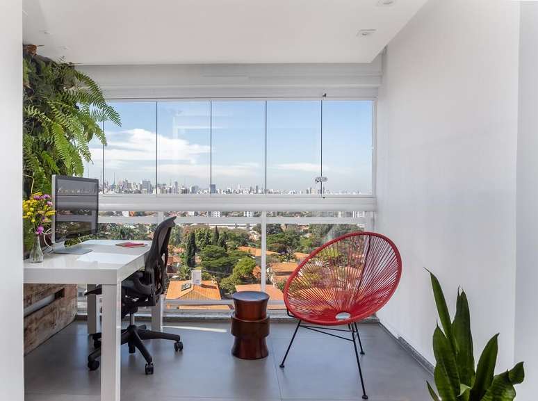 4. A varanda integrada a sala de estar deu vida ao home office do casal. Foto: JP Image