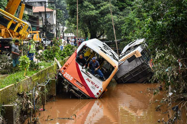  Ônibus é retirado por guindaste do canal da Avenida Washington Luís, em Petrópolis