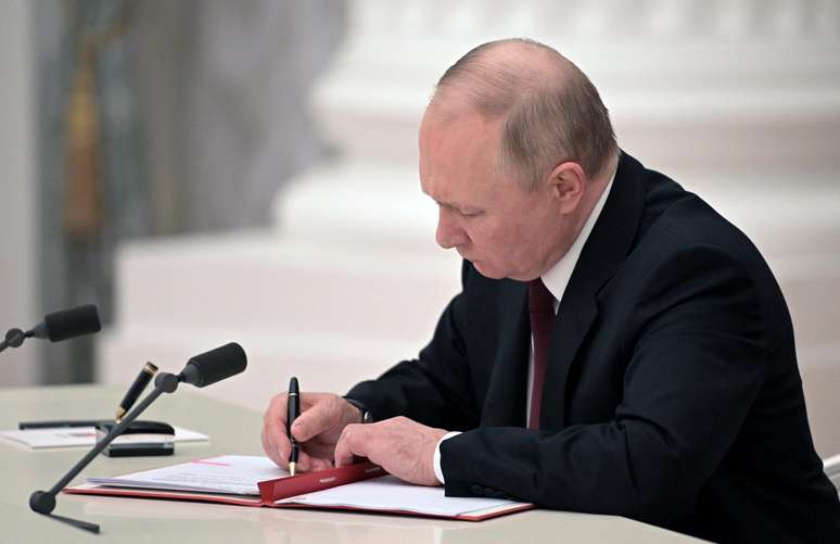 Vladimir Putin assina decreto reconhecendo a independência das repúblicas separatistas do leste ucraniano, durante uma transmissão ao vivo na TV