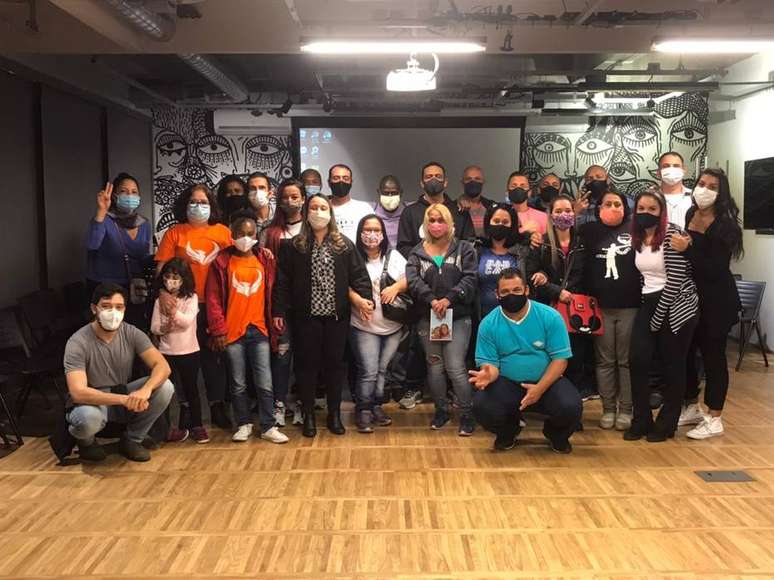 Karine (em primeiro plano, de casaco e calça pretos, camiseta quadriculada) e egressos do sistema prisional ao final de uma palestra no Instituto Responsa. 