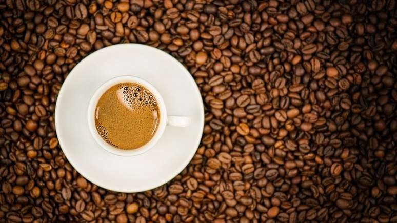 Xícara de café em cima de grãos de café