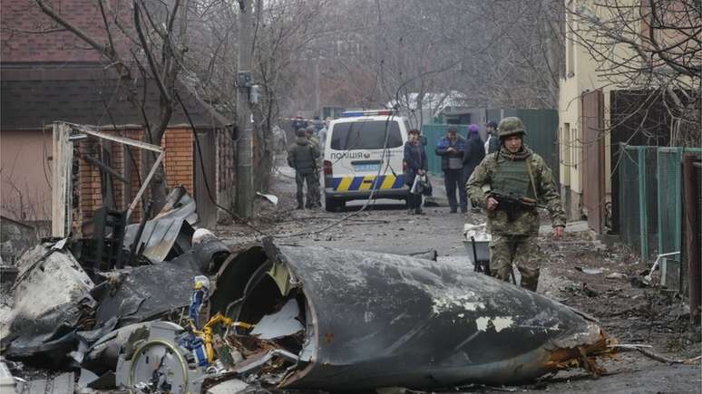 Soldado ao lado de destroços de avião militar abatido na Ucrânia