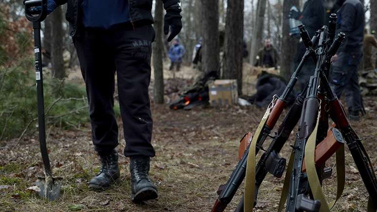 Membros das unidades de defesa territorial da Ucrânia cavam trincheiras no meio da floresta, perto de Kiev