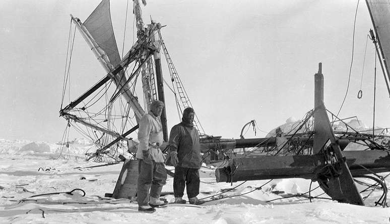 Shackleton (à direita) olha para os restos avariados do navio pouco antes de ir para as profundezas