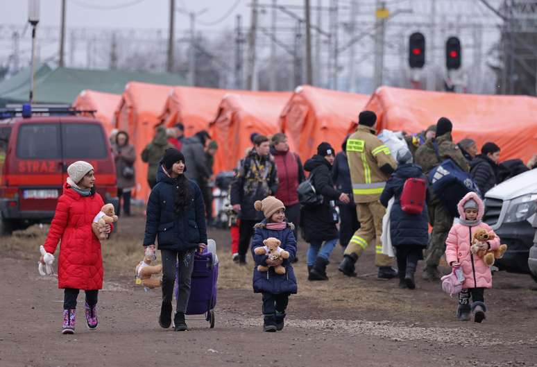 Famílias ucranianas aguardam em tendas vistas na fronteira do país, antes de embarcarem em trem com destino à Polônia.