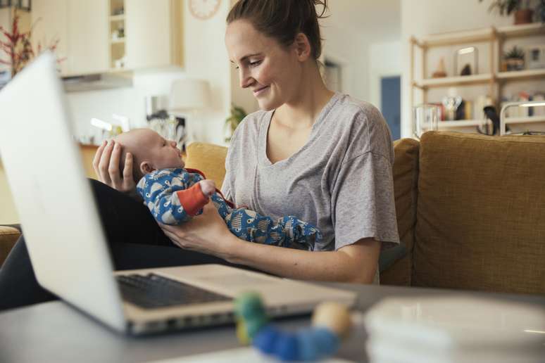 Mãe-segurando-bebê-no-colo-diante-do-computador