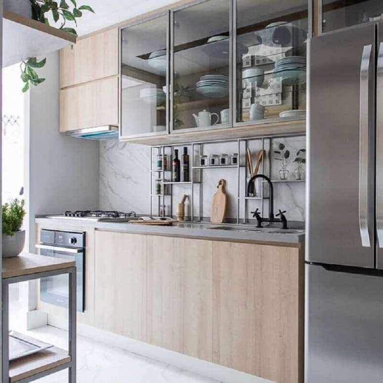 34. Cozinha de madeira decorada com bancada de quartzo cinza e arm&aacute;rio a&eacute;reo com portas de vidro &ndash; Foto: Carol Miluzi