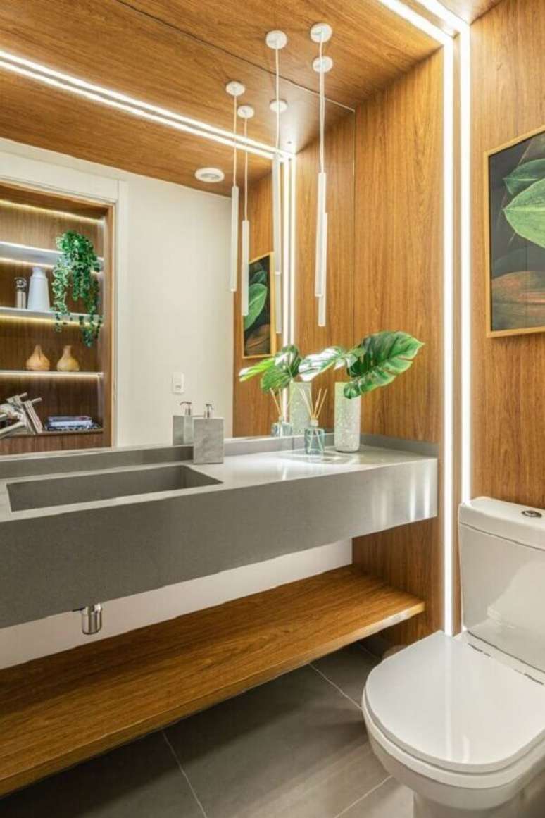 39. Lavabo moderno com pedra de quartzo cinza claro e revestimento de madeira na parede &ndash; Foto: Ruiam Vieira Interiores