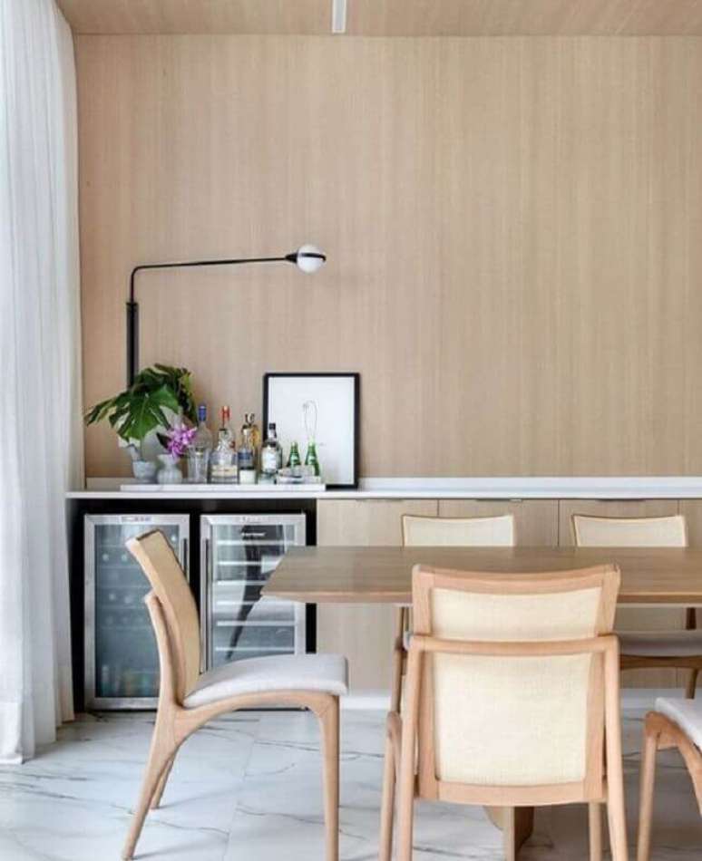 8. Sala de jantar amadeirada decorada com lumin&aacute;ria de parede minimalista &ndash; Foto: Marina Banzato