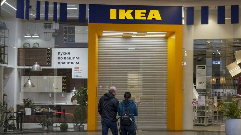 Um casal do lado de fora de uma loja Ikea fechada em Moscou