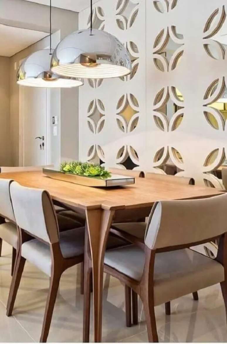 2. Lustre pendente com acabamento metálico e arranjo de flores para mesa de jantar. Fonte: Conexão Décor