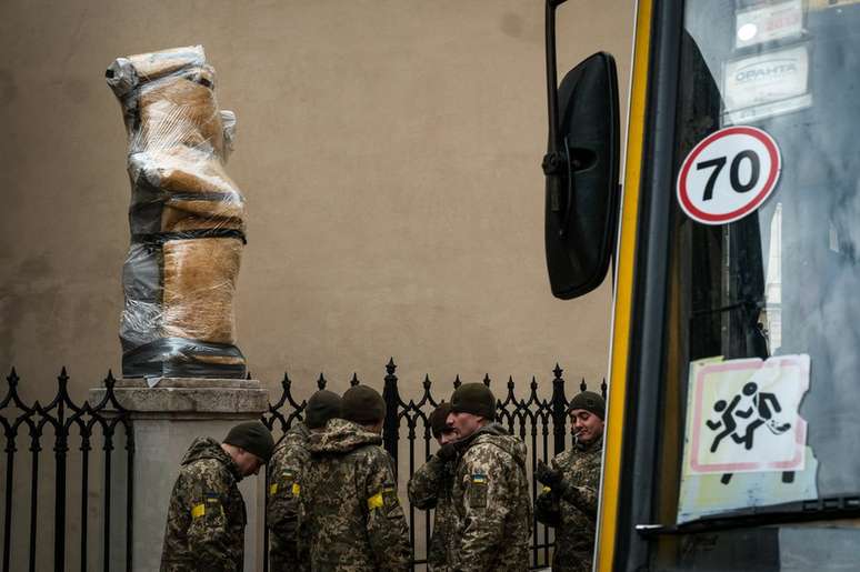 Soldados do lado de fora de uma igreja de Lviv onde estátuas foram protegidas